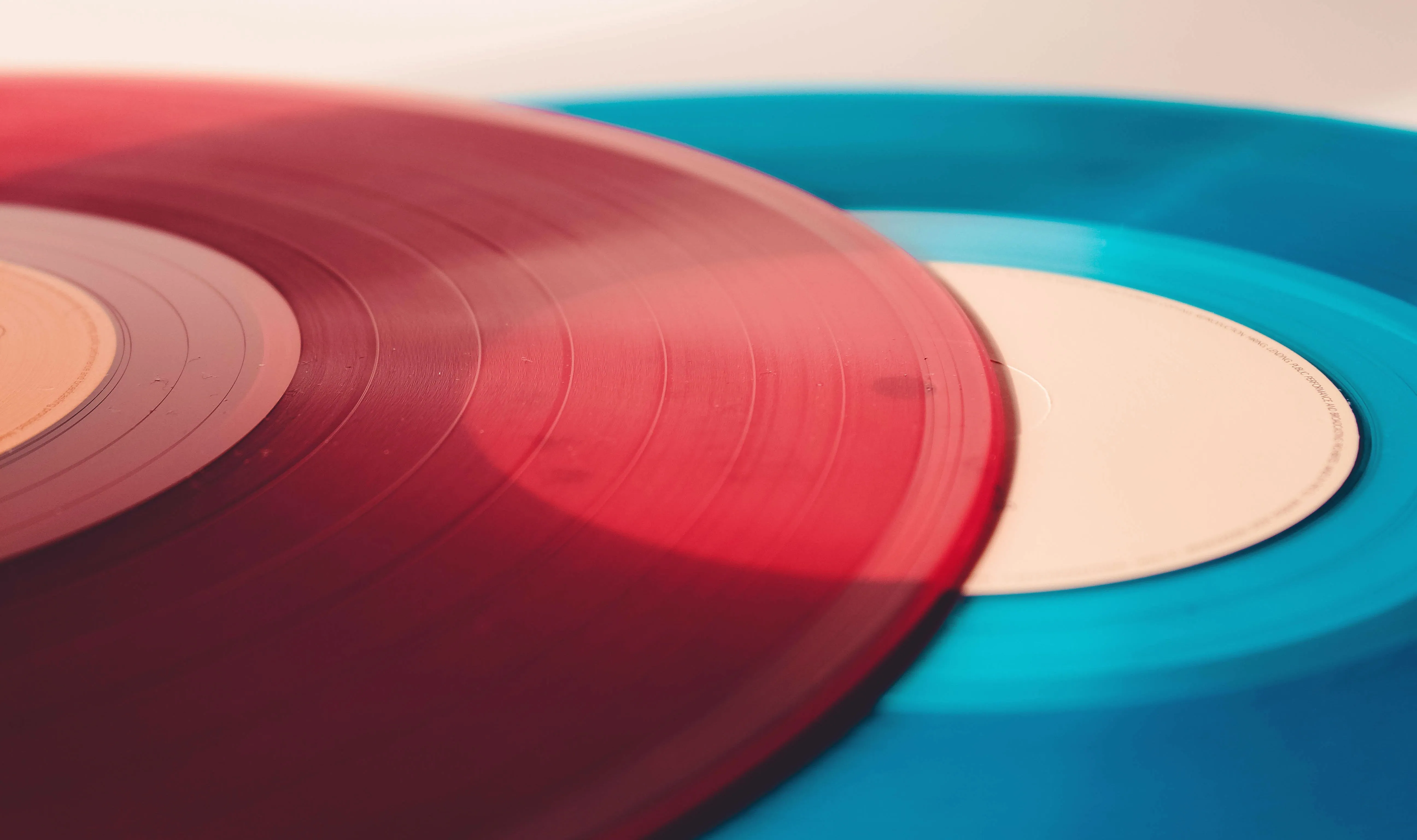 Close-up of a red vinyl record lying on a blue one